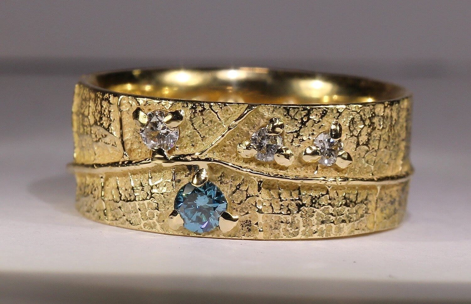 Alliance Ligne de Vie Champagne - constellation de pierres précieuses Bourgeons - trois diamants blancs et un diamant bleu - or jaune - texture feuille - Collection « Nos Inspirations : Végétal » - Atelier du Soleil Fou