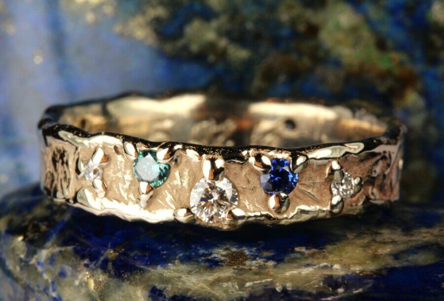 Alliance Sur la Route – Constellation Cassiopée – Atelier du Soleil Fou Alliance Sur la Route - constellation de pierres précieuses Soleil - un diamant - or blanc naturel - Diamants, Saphir, Émeraude - Collection « Nos Inspirations : Feu » - Atelier du Soleil Fou
