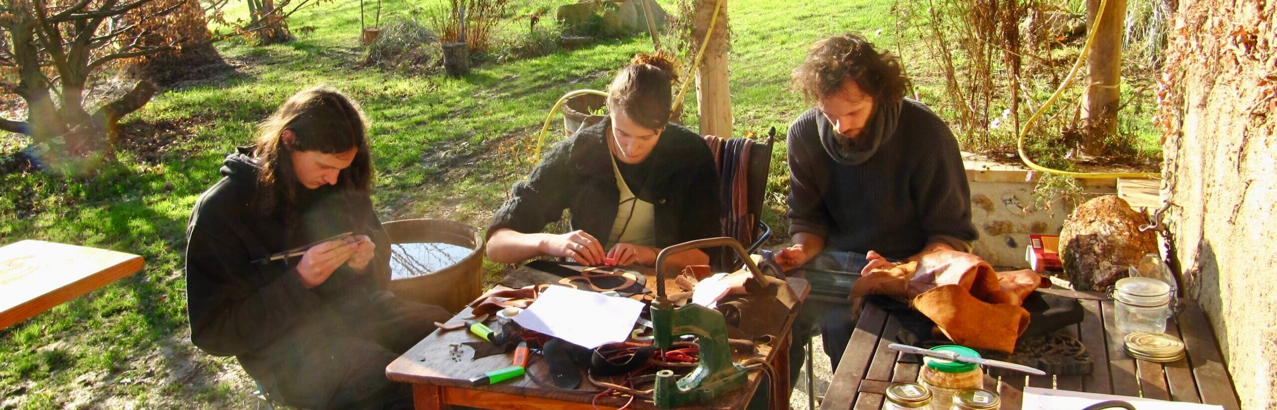 Les trois enfants du créateur Yves-Dominique Audollent au travail sur la terrasse de l"atelier - Atelier du Soleil Fou