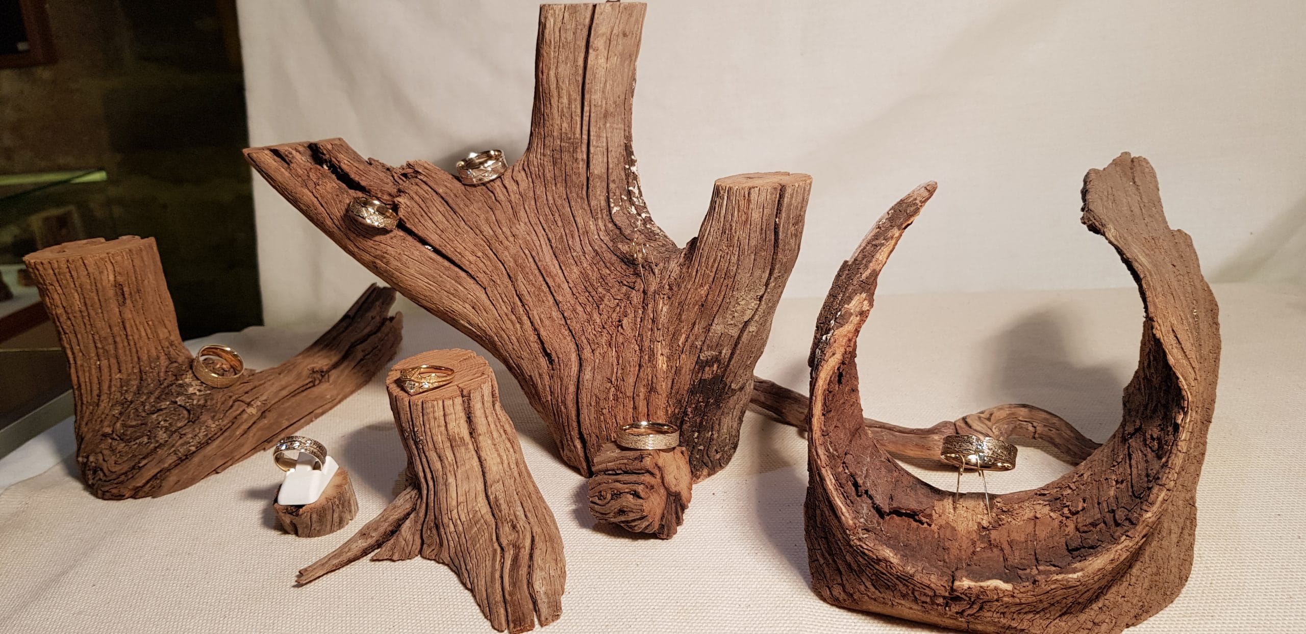 Dans une vitrine du showroom - Atelier du Soleil Fou et de la Lune Amoureuse Vos alliances originales à Paris : les bijoux de l'Atelier du Soleil Fou et de la Lune Amoureuse exposés dans une vitrine aux éléments organiques de bois.