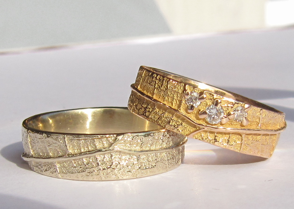 Un couple d'alliances Ligne de Vie en or jaune avec diamants et or blanc naturel.