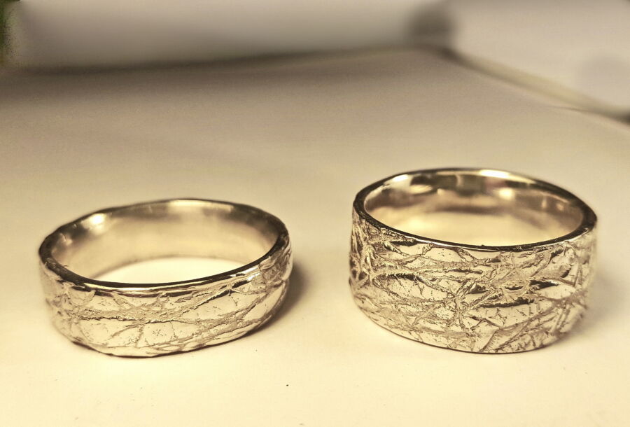 Duo d’alliances pour hommes Regard de Cœur en or blanc, texture ajourée de branches. Duo d'alliances pour hommes Regard de Cœur en or blanc, texture ajourée de branches.