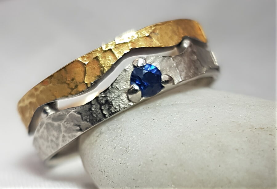 Alliance démontable Onde qui Relie en or jaune martelé et or blanc, sertie d'un saphir bleu.