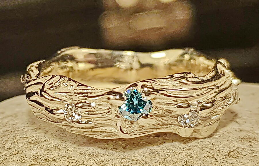 Alliance artisan d’art Sarment de Cœur en or jaune, sertie d’un saphir bleu et de diamants. Alliance artisan d'art Sarment de Cœur en or jaune, sertie d'un saphir bleu et de diamants.