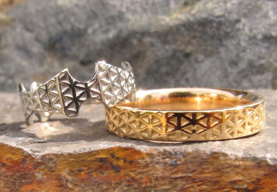 Alliances Petite Étoile en or blanc et or jaune, motif géométrique, sur la roche.